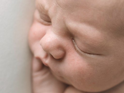 SESIONES DE NEWBORN EN GIJON, OVIEDO, TIÑANA, ASTURIAS Y ALREDEDOREDS Bebé dormido, con rostro tierno y manos sobre la mejilla.