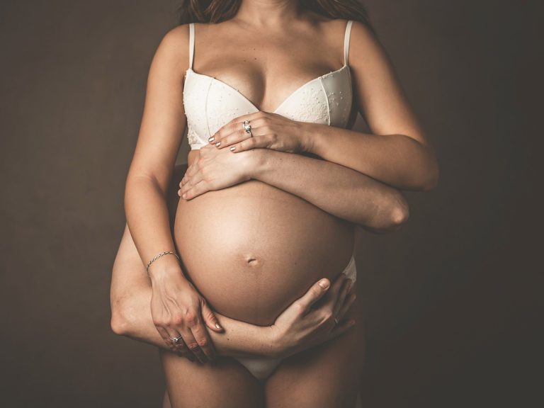 img source='pic.gif' alt=FOTOS EMBARAZO BARCELONA Mujer embarazada con manos abrazándola, transmitiendo ternura y conexión.